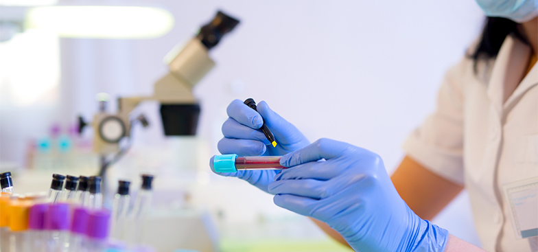 a lab worker holds a vial of blood