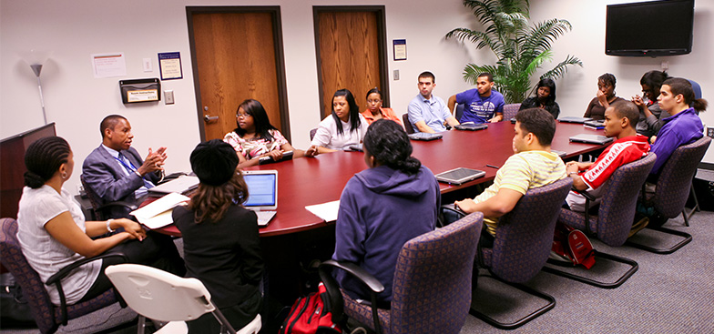 members gathered around a table talking