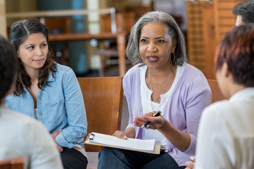 a woman discusses a topic with a group