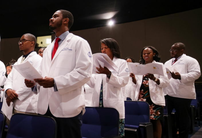 a group of UME Students wearing whitecoats